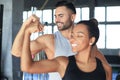 Cheerful sportive couple training together and showing biceps at the gym Royalty Free Stock Photo