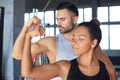 Cheerful sportive couple training together and showing biceps at the gym Royalty Free Stock Photo