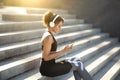 Cheerful sporty girl resting on stairs, training outdoors Royalty Free Stock Photo