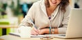 Cheerful student doing homework by laptop at cafeteria table