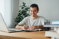 Cheerful student making notes from laptop while online learning Royalty Free Stock Photo