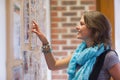 Cheerful student pointing at notice board