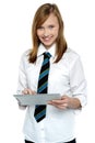 Cheerful student in school attire using tablet pc