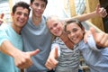 Cheerful students showing thumbs up