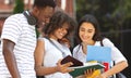 Cheerful students studying outdoors, standing in college campus, checking classes schedule Royalty Free Stock Photo