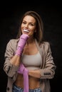 Lively chic sportswoman in jacket and bra showcasing boxing wraps and mouthguard