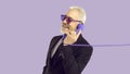 Cheerful stylish and charismatic senior man talking on landline phone on purple background.