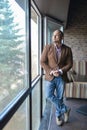 Cheerful and stylish indian man standing near the window Royalty Free Stock Photo