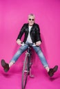 Cheerful stylish senior man wearing leather jacket riding bicycle Royalty Free Stock Photo