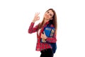Cheerful stylish student girl with backpack on her shoulders and folder for notebooks in her hands posing and showing OK Royalty Free Stock Photo