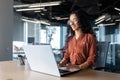 Cheerful and successful indian woman programmer at work inside modern office, tech support worker with laptop typing on Royalty Free Stock Photo