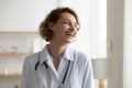 Cheerful successful young female doctor looking away and laughing Royalty Free Stock Photo