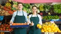 Supermarket workers selling fruits.