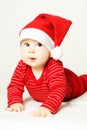 Cheerful surprised baby in red Santa hat