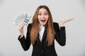 Cheerful surprised lady looking camera while holding dollars in hand