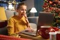 Cheerful surprised woman social networking at Christmas