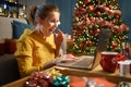 Cheerful surprised woman social networking at Christmas