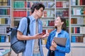 Cheerful talking college students male and female inside library Royalty Free Stock Photo