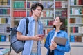 Cheerful talking college students male and female inside library Royalty Free Stock Photo