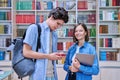 Cheerful talking college students male and female inside library Royalty Free Stock Photo