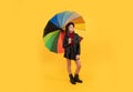 cheerful teen child hold colorful parasol. kid in hat with rainbow umbrella.