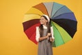 cheerful teen child under colorful parasol. kid in beret with rainbow umbrella. Royalty Free Stock Photo