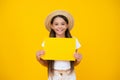 cheerful teen girl hold empty advertisement paper with copy space on yellow background