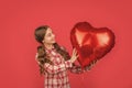 cheerful teen girl hold love heart balloon on red background Royalty Free Stock Photo