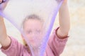 Cheerful teen girl holding a purple slime and looking through. Royalty Free Stock Photo