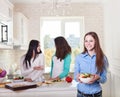 Cheerful teen girls preparing salad together