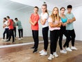 Cheerful teenage boys and girls having fun in choreography class, posing with female trainer Royalty Free Stock Photo
