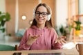 Cheerful teenage girl having video lesson using laptop at home, talking and gesturing, pc web camera view Royalty Free Stock Photo