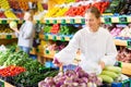 Cheerful teenage girl shopping for turnip in grocery store Royalty Free Stock Photo