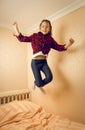 Cheerful teenage jumping high in her bed Royalty Free Stock Photo