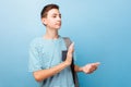 Cheerful teenager with clapping hands, on a blue background