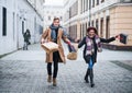 Cheerful teenager couple with paper bags walking down the street in winter. Royalty Free Stock Photo