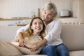 Cheerful teenager girl hugging attractive mature grandma from behind