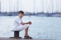 Cheerful teenager looks at ship at sea and dreams