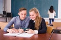 Cheerful teenagers with phone in schoolroom