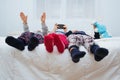 Cheerful three children playing on the phone on the bed