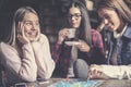 Three happy girls playing board game. Royalty Free Stock Photo