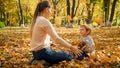 Cheerful toddler boy playing with his mother in autumn park Royalty Free Stock Photo