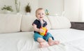 Happy cheerful toddler boy sittingin bed with toy car Royalty Free Stock Photo