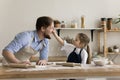 Cheerful toddler girl leaving floury spot on fathers face