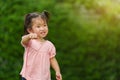 Cheerful toddler girl playing grass flower in field