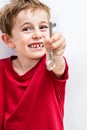 Cheerful toothless boy holding a key forward for fun creativity