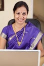 Cheerful traditional woman using laptop computer