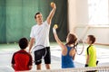 Cheerful trainer teaching kids playing tennis Royalty Free Stock Photo