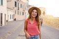 Cheerful traveler girl walking towards the camera on street in old town Royalty Free Stock Photo