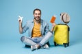 Cheerful traveler tourist man in yellow clothes isolated on blue background. Passenger traveling abroad on weekend. Air